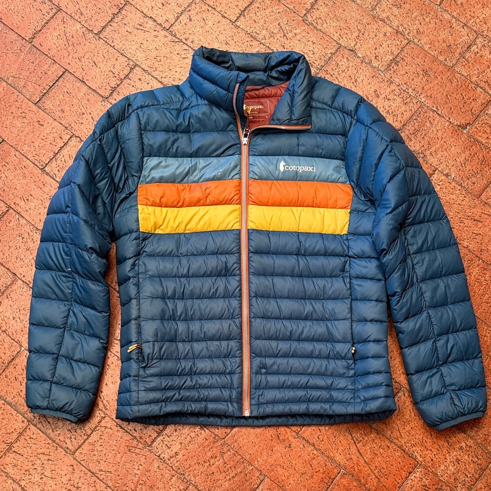Cotopaxi Men's Dark Blue Fuego Jacket with Orange and Yellow Stripes